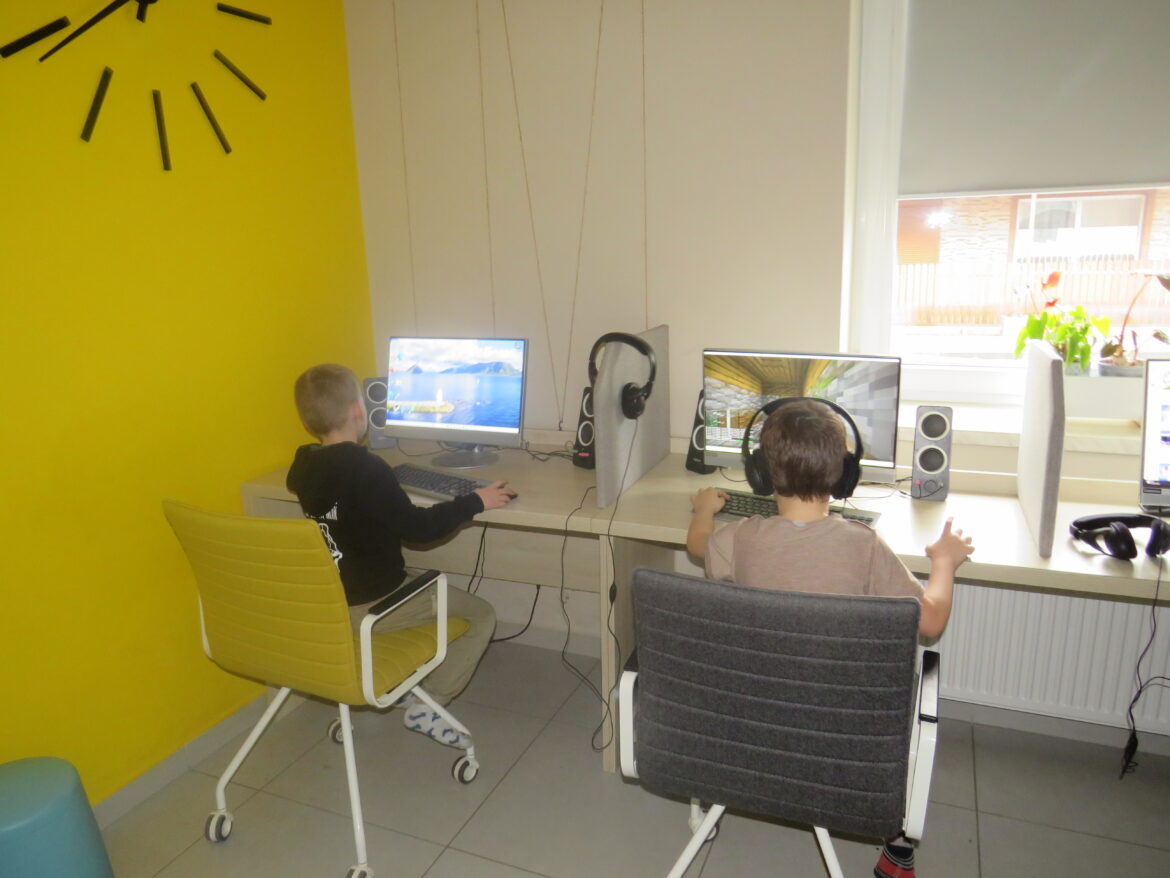 Zdjęcie przedstawia dzieci grające w gry komputerowe